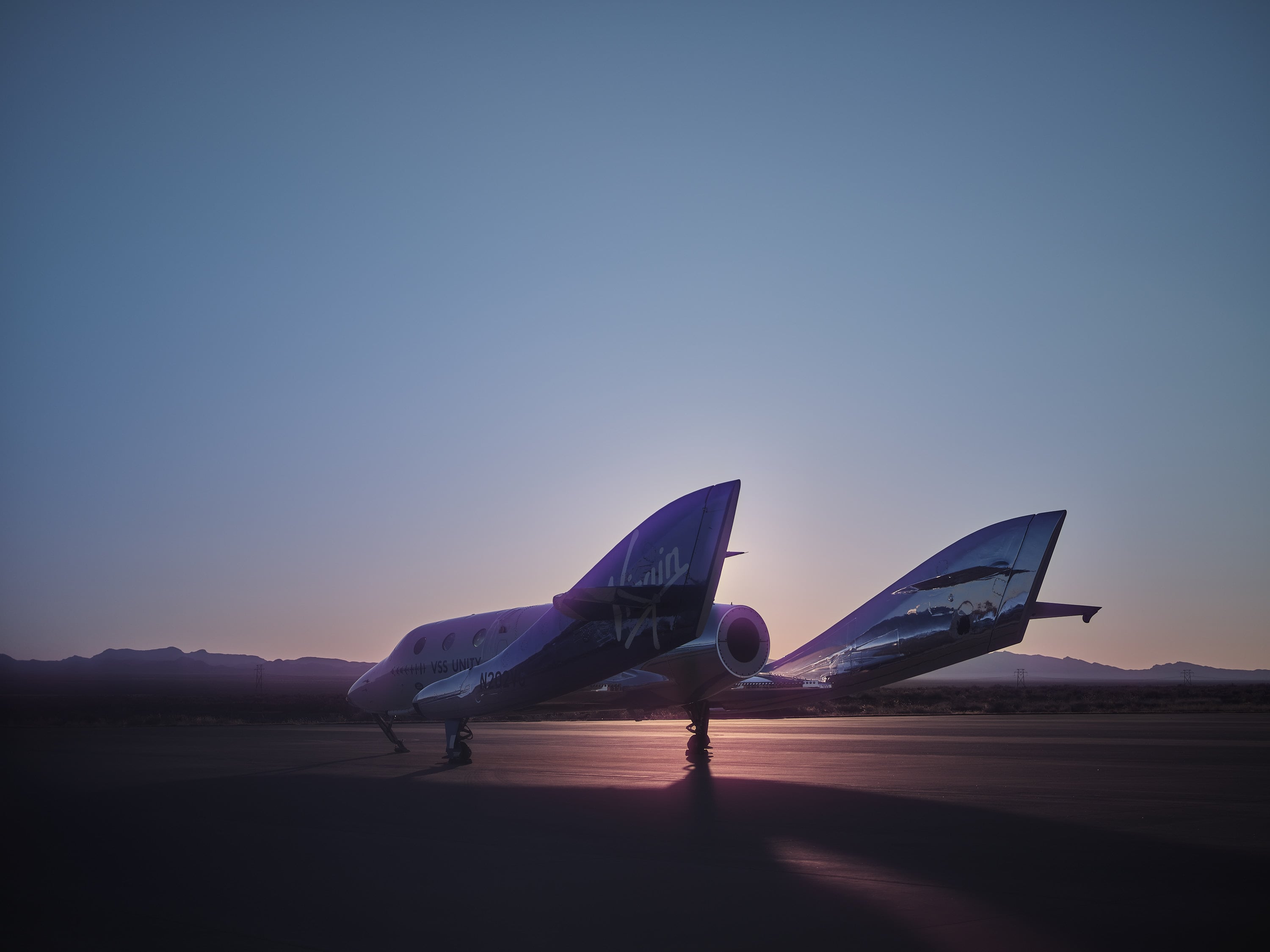 Virgin Galactic spaceplane climbing into the darkness under rocket power, illustrating the excitement of a future suborbital space flight